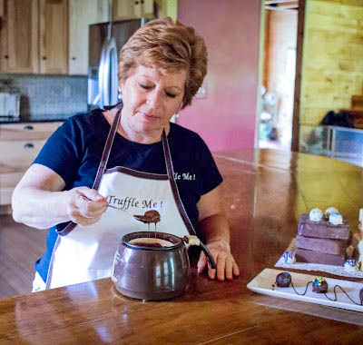 Diane Haase, owner of Truffle Me! making truffles with blocks of white and milk chocolate